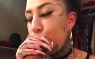 Teen chick with nasty tattoos blowing a huge dildo